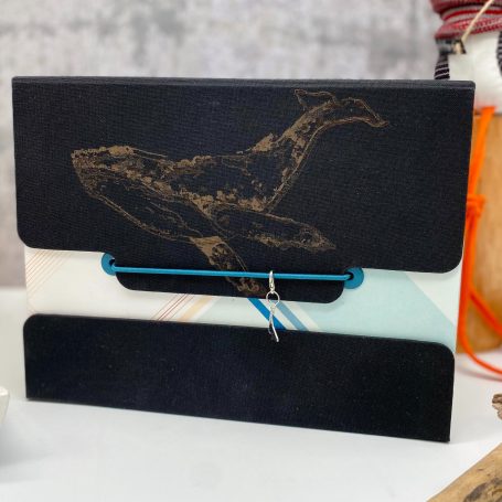 Fertige Werkstücke Schwarze Mappe mit Wal-Motiv und bunten Akzenten im Hintergrund.